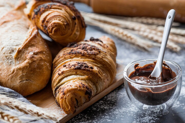 Delicious freshly baked croissants with chocolate on a dark background. French breakfast. Delicious...