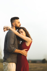 A couple in love are hugging in a field. A girl and a man on a romantic date. Romantic relationship. Hugs of man and woman.