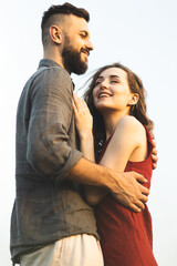 A couple in love are hugging in a field. A girl and a man on a romantic date. Romantic relationship. Hugs of man and woman.