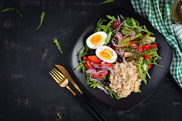 Breakfast oatmeal porridge with boiled egg, cherry tomatoes, asparagus and arugula. Healthy balanced food. Top view, overhead