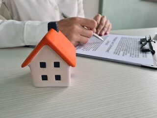 Woman signing a house purchase contract in office closeup
