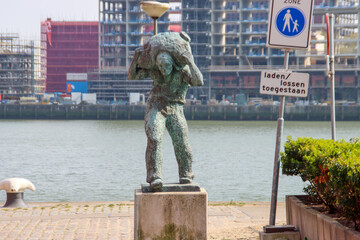 Statue of a dockworker along the quay of the Wilheminahaven at the Kop van Zuid in Rotterdama