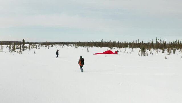 Drone footage of a skier para-skiing with a parachute on a windy winter day in Kenai, Alaska.