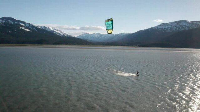 Drone footage of a water skier para-skiing with a parachute on a windy summer day in Turnagain Arm of the Cook Inlet in Alaska.