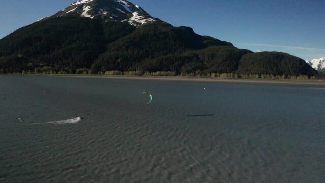 Drone footage of a water skier para-skiing with a parachute on a windy summer day in Turnagain Arm of the Cook Inlet in Alaska.