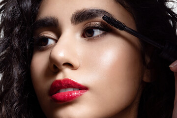 Close-up of a beautiful woman wearing black mascara on her eyelashes. Model Beauty Portrait