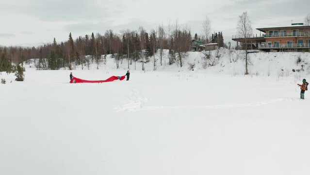 Drone footage of a skier para-skiing with a parachute on a windy winter day in Kenai, Alaska.