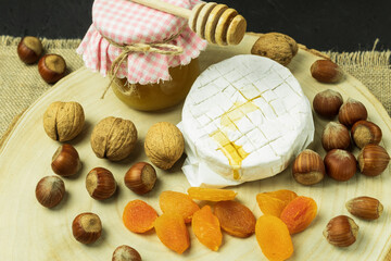 A drop of honey drips onto camembert cheese