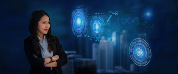 Portrait of confident young Asian businesswoman standing with crossed arms in blurry office with double exposure of futuristic immersive business interface. Concept of GUI and hi tech. Toned image