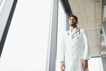 Fototapeta premium Portrait of confident Asian Indian medical doctor standing at hospital building