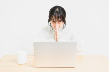 PCを使いながらお願いしている若い女性