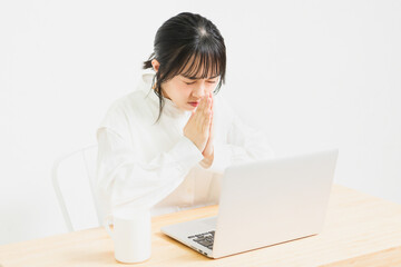 PCを使いながらお願いしている若い女性