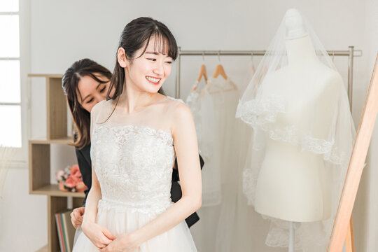 結婚式の準備でウェディングドレスの衣装合わせをするアジア人女性（試着・フィッティング）
