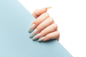 Manicured woman's hand holding blue paper.