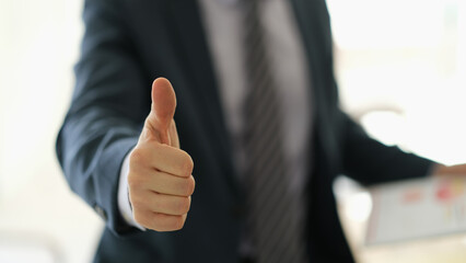 Businessman in suit showing thumb up gesture ok closeup. Successful business concept