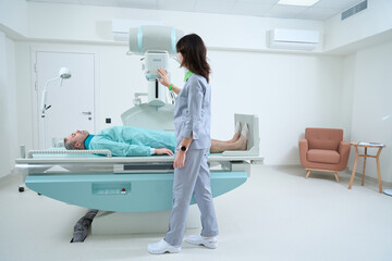 Female radiologist controling X-ray process in clinic