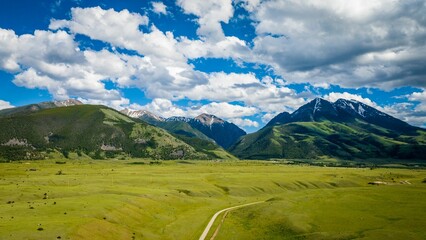 Gorgeous aerial view of tall mountains in the Paradise Valley in Montana under a bright cloudy sky