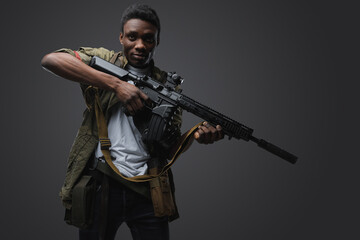 Fototapeta premium Studio shot of somali buccaneer of african ethnic aiming rifle isolated on gray.