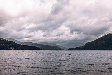 Fototapeta na wymiar Beautiful cloudy sky over Loch Lomond Lake in the mountains in Scotland