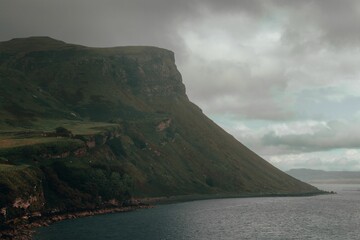 Beautiful shot of the historic Isle of Skye cliff over the water under a cloudy sky in Scotland