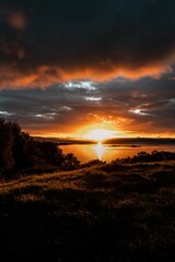 Vertical shot of a bright orange sunset sky over the water in Isle of Skye, Scotland