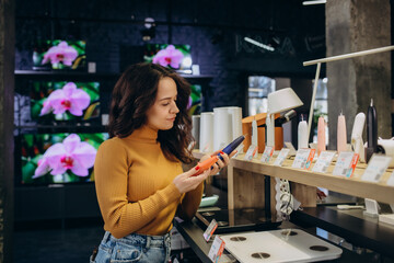 a woman in an electronics store chooses a toothbrush