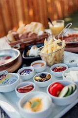View of sauces, vegetables and fries on white plate