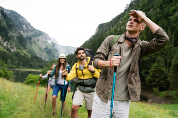 Group of happy fit friends hiking, trekking together outdoor nature