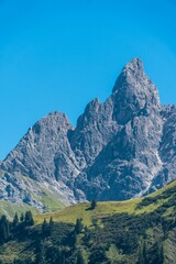 Obraz premium Vertical shot of a mountain with a clear blue sky in the background