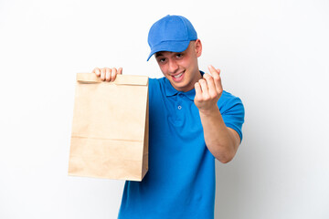 Young Brazilian man taking a bag of takeaway food isolated on white background making money gesture