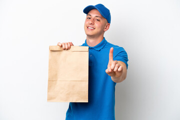 Young Brazilian man taking a bag of takeaway food isolated on white background showing and lifting a finger