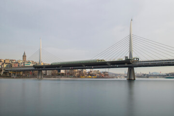 Obraz premium Long exposure. View of Haliç Metro Bridge connecting Azapkapı (Beyoğlu) and Unkapanı (Fatih) (Halic Metro Bridge). blue sky Istanbul Turkey