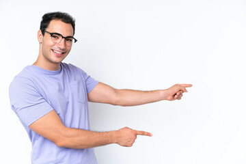 Young caucasian man isolated on white background pointing finger to the side and presenting a product