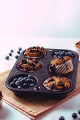 Vertical shot of the flat lay tasty muffins with blueberry forest fruit on the kitchen board