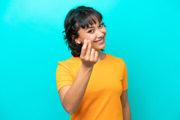 Young Argentinian woman isolated on blue background making money gesture