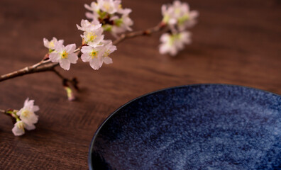 Spring dining table or cafe. Plate and cherry branch on the table. 春の食卓またはカフェ。テーブルの上のお皿と桜の枝