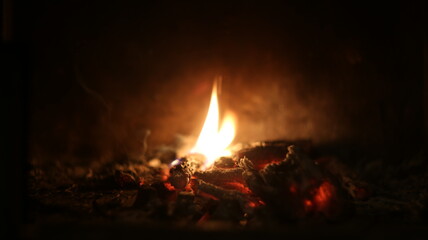 The lash of flames, fire, hot coals in the fireplace, dark background