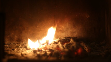 The lash of flames, fire, hot coals in the fireplace, dark background