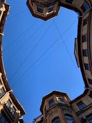 Fototapeta na wymiar View from below on the blue sky, the courtyard-well of the original form, located in the center of St. Petersburg.