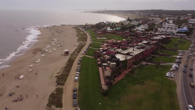 Red residential buildings along Playa Brava, Punta del Este beach in Uruguay. Aerial orbiting