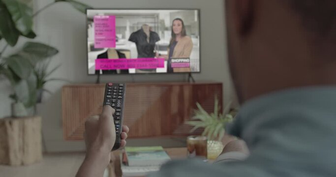 African American Male at Home Watching Shopping channel on Television on Sofa