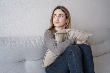 young attractive woman sitting at home living room couch tired and worried suffering depression...