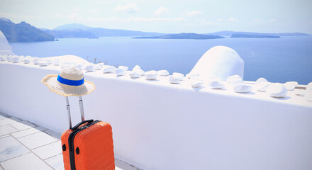 Orange luggage with hat and landscape view of Oia town in Santorini island in Greece , Greek...