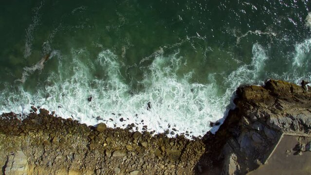 Aerial Top Panning Shot Of Cars Parked By Splashing Sea Coastline On Sunny Day - Camarillo, California