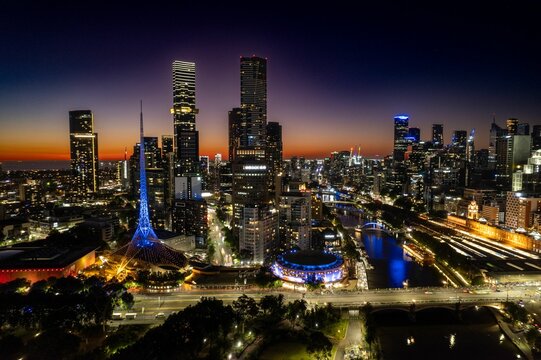 Aerial shot of the tall buildings glowing in night lights at sunset in Melbourne, Australia.