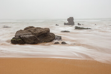 Cantabrian coast; misty morning at a rocky beach in the vicinity of the village of Liencres, Cantabria Spain
