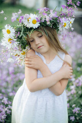 Obraz na płótnie Canvas little girl in a wreath of flowers