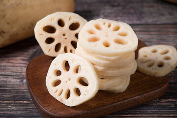 Fototapeta premium fresh raw lotus root slices on wooden table