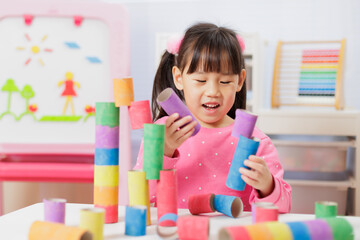 young girl was making colorful craft at home