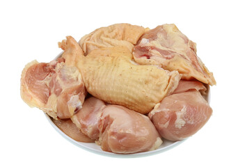 Pieces of fresh rustic organic chicken lie on a plate isolated